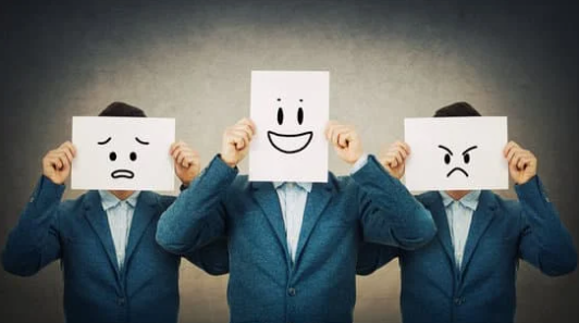 3 men holding emojis infront of their faces