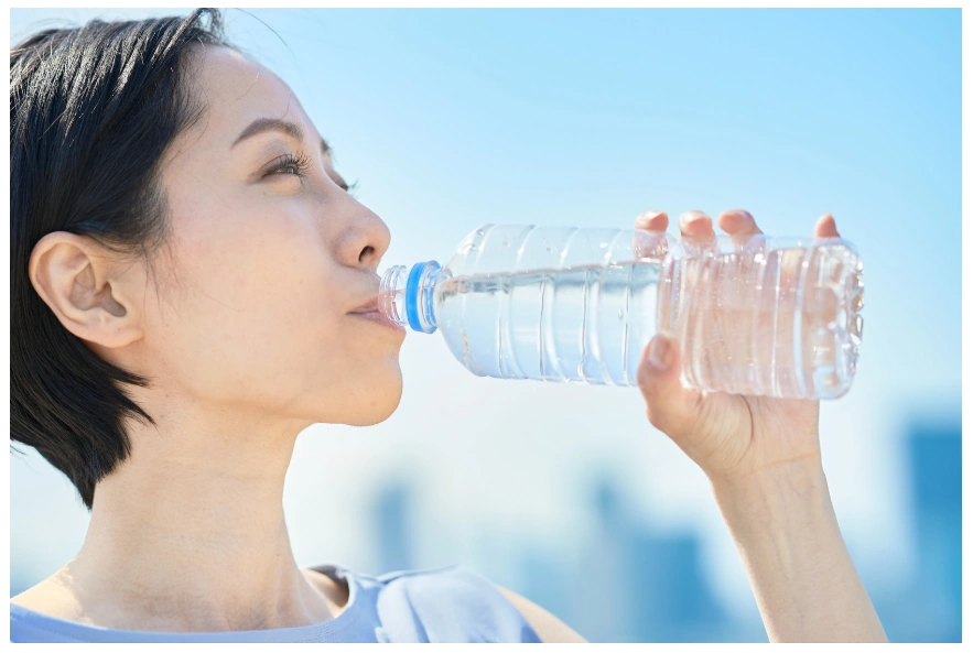 woman drinking from a water bottle